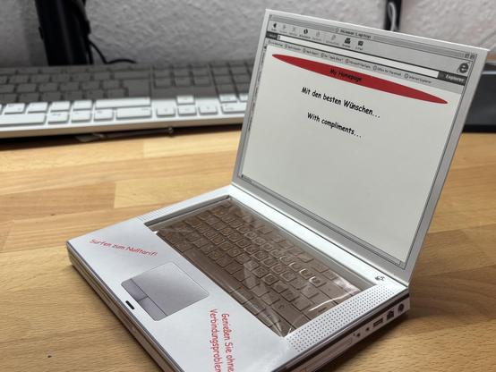 Ein kleiner Karton in Form eines Notebooks, dessen Tastatur eine Tafel Schokolafe ist. Er zeigt ein sehr altes User Interface und hat Werbesprüche auf den Handauflagen: „Surfen zum Nulltarif“ „Genießen Sie ohne Verbindungsprobleme“

Auf dem Bildschirm ist Platz für Glückwünsche an den Beschenkten.