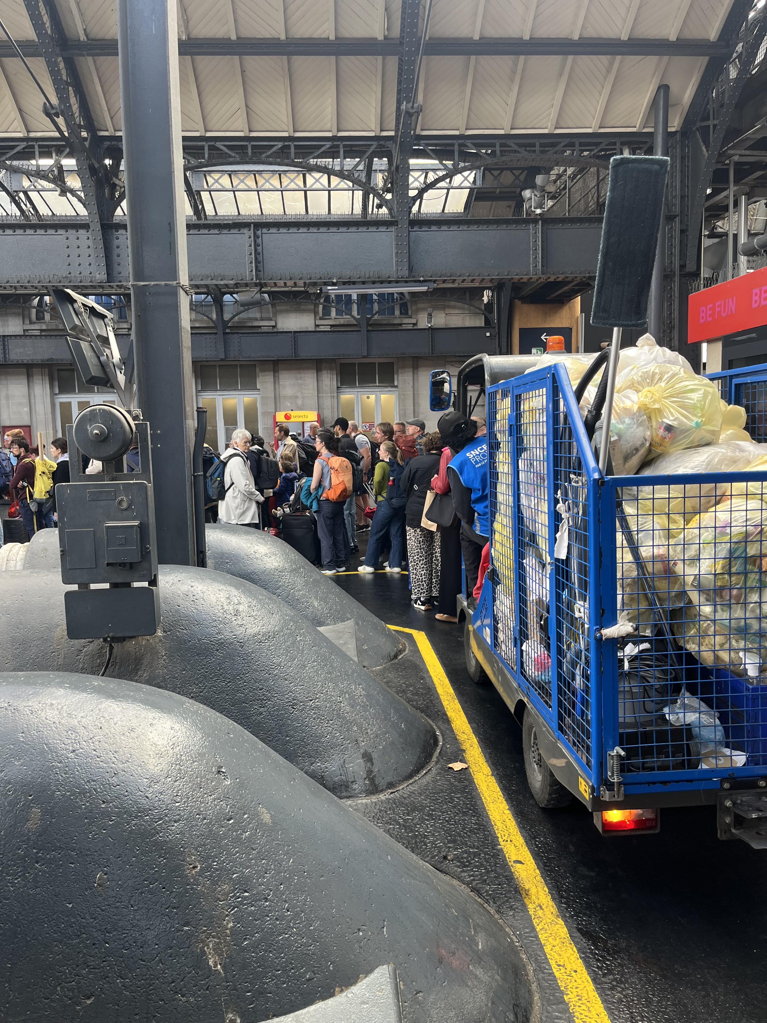 A rubbish truck and people queuing 