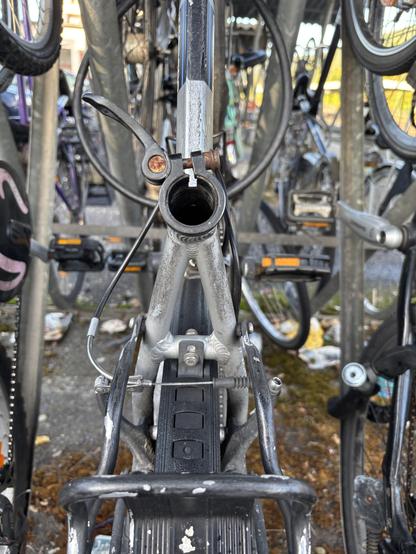 Der mittlere Holm eines Fahrrads mit fehlender Sattelstange und ohne Sattel. Der Spannbügel ist offen.