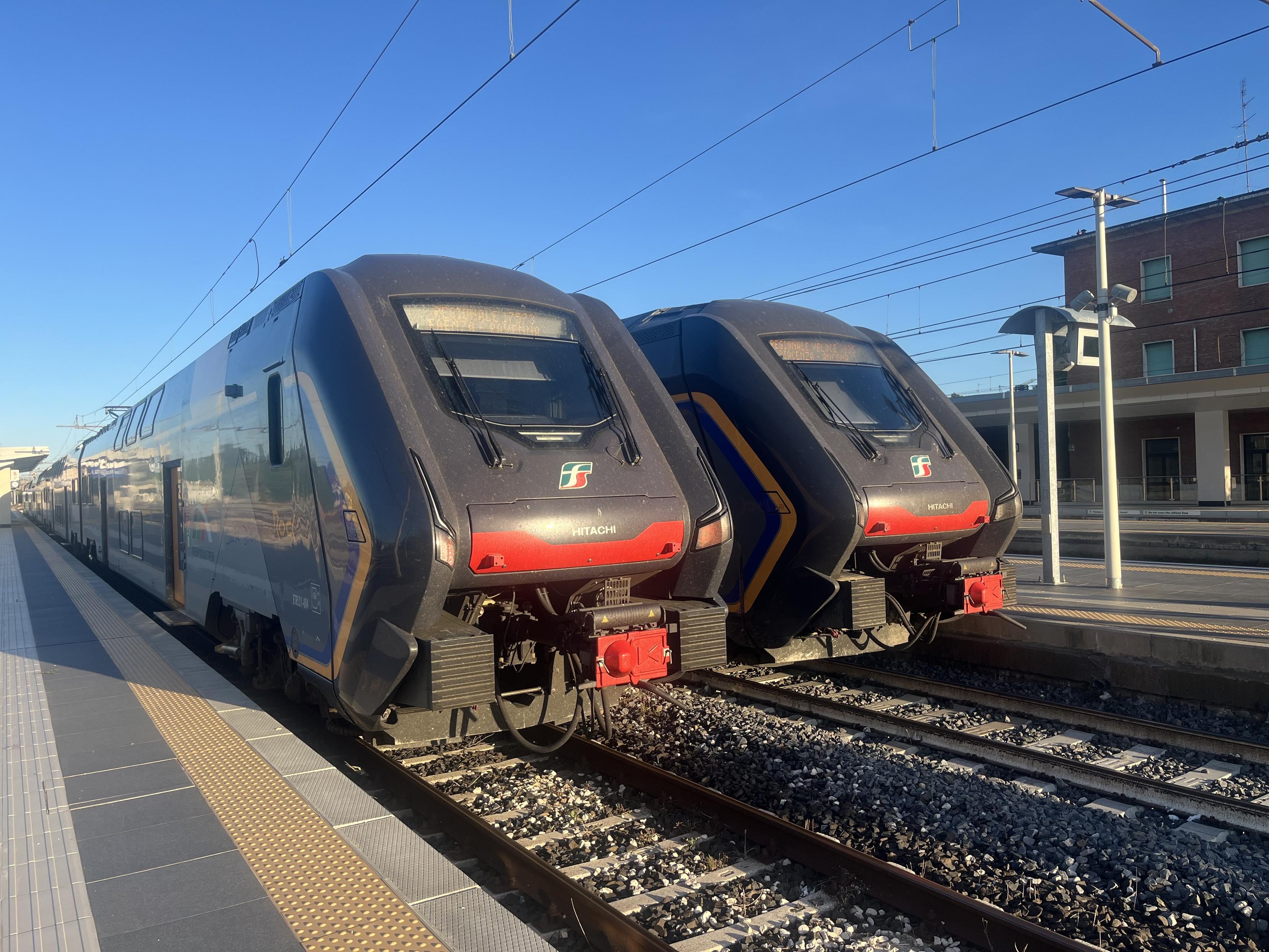 Two Hitachi Rock EMUs. Both are in the two tone grey and orange livery. At platforms 6 and 5 at Faenza station
